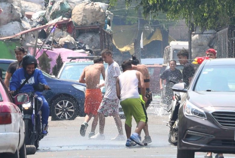 A la izquierda y debajo, guerra de agua en colonias de Ciudad de México, donde a pesar de la escasez del vital líquido, los jóvenes se resisten a abandonar la tradición del Sábado Santo