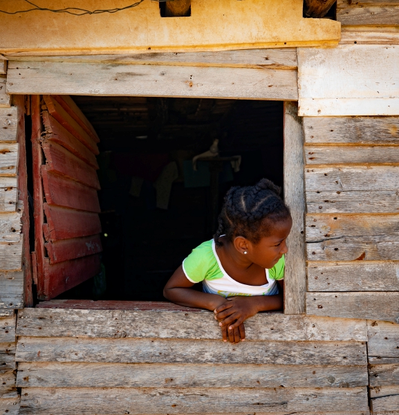 AME109. MATANZAS (CUBA), 19/03/2024.- Una niña se asoma desde una ventana de su casa en una humilde barriada de chabolas junto a la localidad de Santa Marta el 12 de marzo de 2024, en la provincia de Matanzas (Cuba). En medio de la oscuridad de su casa, Catalina, de 35 años, repasa los problemas de su día a día, similares a los que padecen en Cuba millones de personas por la grave crisis económica que sufre el país y que ha generado protestas en varias ciudades en los últimos días. Los apagones, de más de diez horas diarias en muchas provincias, son un calvario para muchos y el detonante -más allá de otras causas profundas- de protestas como las de el pasado domingo. EFE/ Yander Zamora