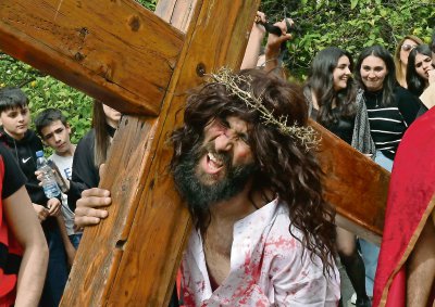 Un joven caracterizado como Jesucristo carga la cruz en una calle de la aldea de Al Qraiyeh, en el sur del Líbano, donde el Viernes Santo es conmemorado por cristianos de la Iglesia católica y occidental