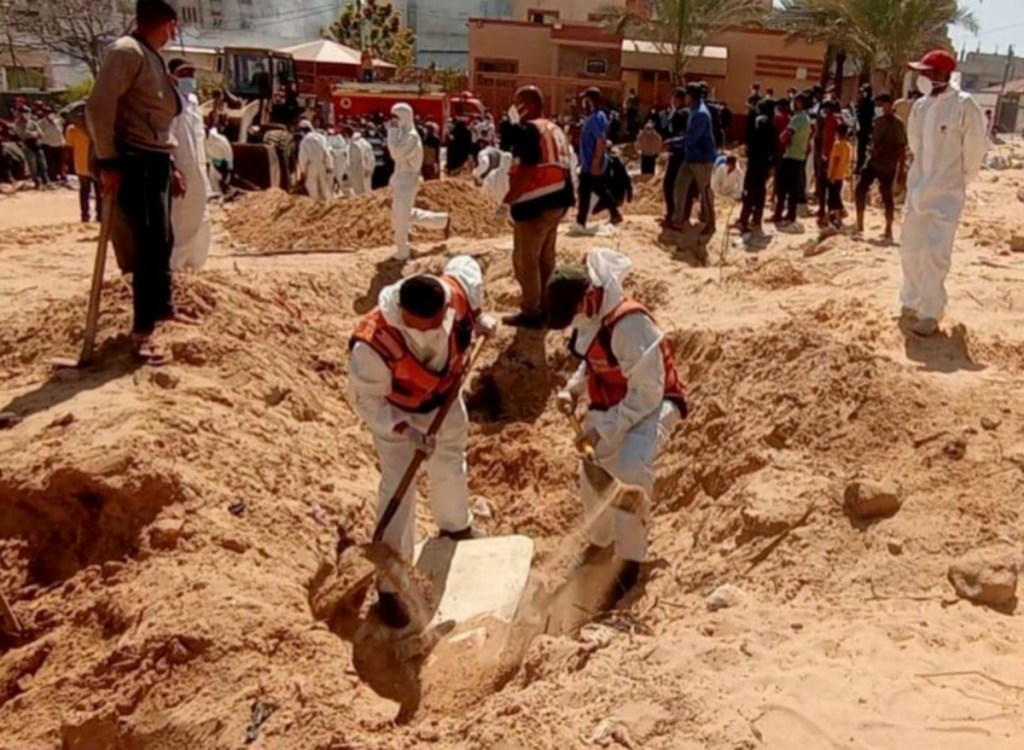 Palestinos recuperan los cadáveres de sus familiares hallados en una fosa común en Gaza. los equipos médicos y de rescate recuperan los cuerpos enterrados en la fosa común en el hospital Naser