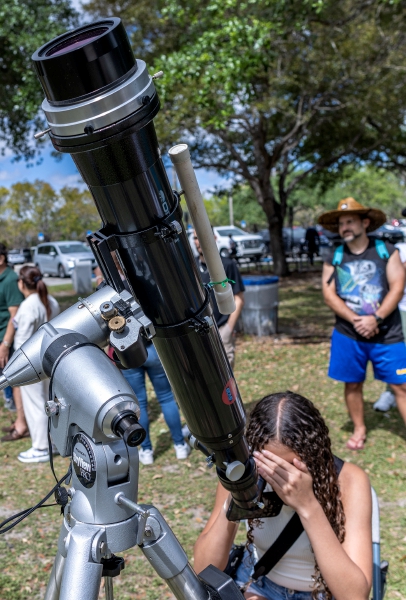 Sobre estas líneas, pajes del Senado frente al Capitolio de Estados Unidos, en Washington. A la izquierda, espectadores aplauden en el “National Mall” de Washington, con el Capitolio a sus espaldas, el eclipse de Sol parcial