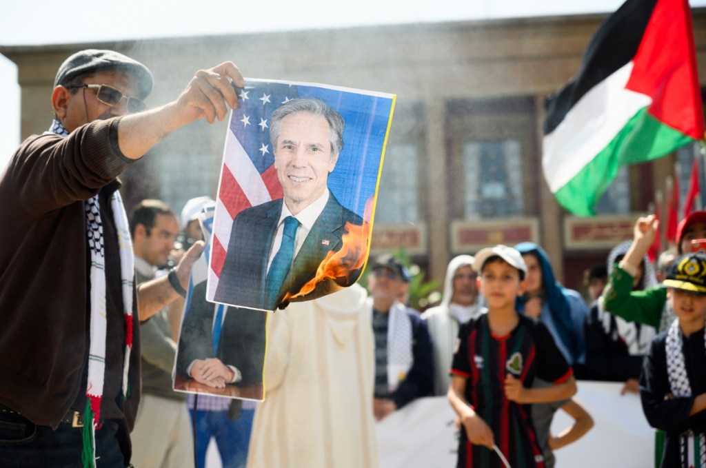 Manifestantes queman una fotografía del secretario de Estado estadounidense, Anthony Blinken, durante una manifestación de solidaridad con el pueblo palestino realizada ayer en Rabat, Marruecos