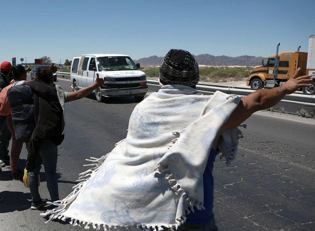 Arriba, campamento de migrantes estancados, con más de 3 mil personas que permanecen en espera de conseguir recursos para llegar a Ciudad Juárez y seguir su camino a Estados Unidos. A la izquierda, un grupo de migrantes camina a un costado de la carretera rumbo a la frontera con Estados Unidos