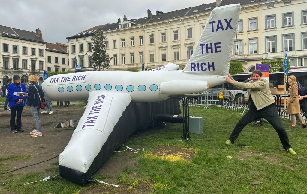 Integrantes de organizaciones que combaten la pobreza colocan un avión inflable frente a la sede del Parlamento Europeo, en Bruselas, Bélgica, para pedir impuestos a las grandes fortunas de la Unión Europea