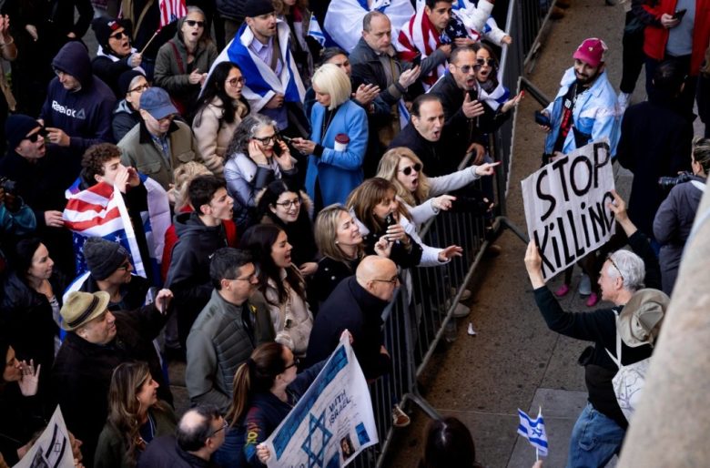 Manifestantes que están a favor de Israel gritan consignas frente a un grupo de protesta en pro de Palestina, a las afueras de la Universidad de Columbia. A la derecha, un estudiante propalestina sostiene un cartel que dice “Vergüenza en UT”, en referencia las siglas de la Universidad de Texas, en Austin