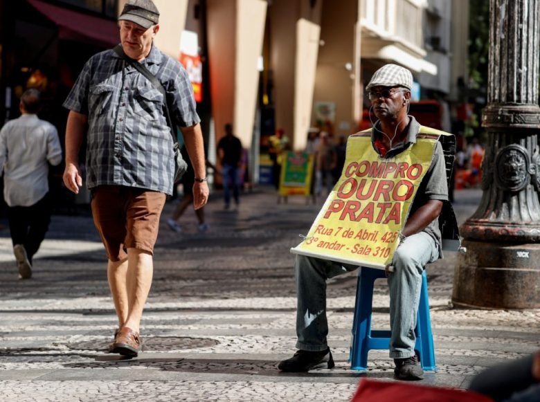 En la imagen, Vanderlei Afonso, de 63 años, trabaja con un anuncio de compra venta de oro en Brasil