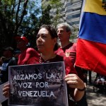 Algunos manifestantes portaban banderas de Venezuela y pancartas en las que se leía “Alzamos la voz por Venezuela” y “Exigir democracia para Venezuela no es un delito”