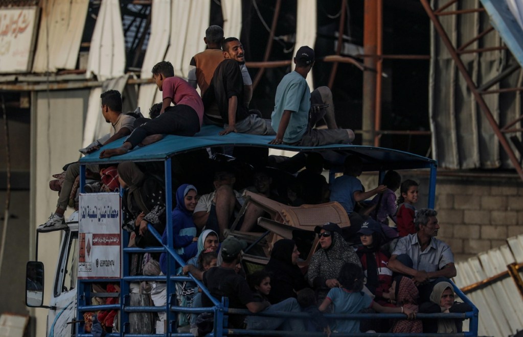 Palestinos desplazados salen con sus pertenencias tras una orden de desalojo emitida por el ejército israelí, en Rafah, al sur de la Franja de Gaza