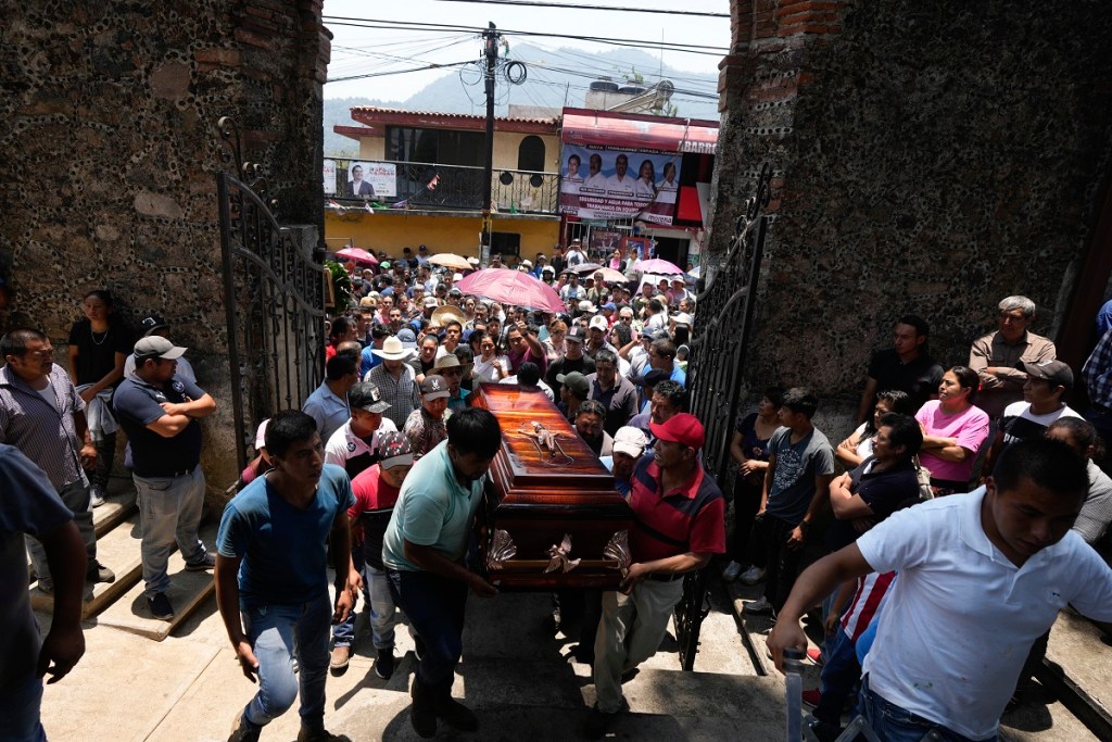 Parientes y amigos introducen a una iglesia el ataúd con los restos de un hombre asesinado en una masacre en Huitzilac, Morelos (Foto de AP)
