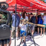 Un pequeño manipula un dispositivo de artillería remoto en la “aldea del ejército” durante las celebraciones del fin de semana del Día de los Caídos en Miami Beach. A la izquierda, otro niño un observa a través de la mirilla telescópica de un rifle de francotirador en el área de equipo militar que instaló el Ejército estadonunidense en la playa de Miami