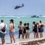 Visitantes de Miami Beach observan un simulacro de una operación contra el tráfico de drogas, en el que se utilizaron helicópteros y lanchas rápidas, durante las celebraciones del Día de los Caídos