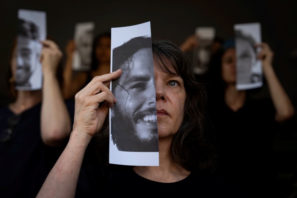 Familiares y defensores de los rehenes cautivos por Hamás en Gaza, sostienen fotos de sus seres queridos durante una protesta en Tel Aviv