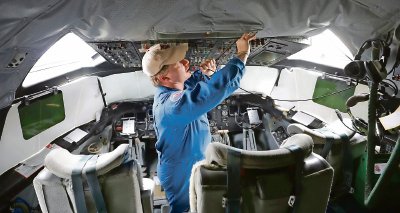 El ingeniero de vuelo de la NOAA Daniel Tyson hace ajustes en la cabina de un avión WP-3D en el aeropuerto Sanford, en Florida