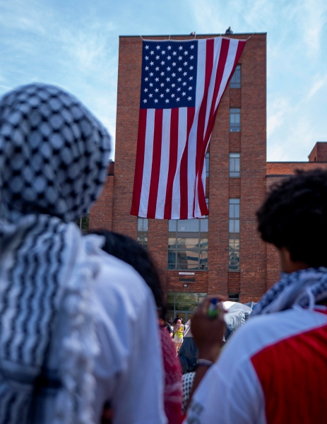 Activistas pro-palestinos reaccionan ante el despliegue de una gran bandera estadounidense en el campamento de manifestantes en el patio universitario de la Universidad George Washington. A la izquierda, manifestación convocada en respuesta a la limpieza de un campamento en la Universidad de Nueva York