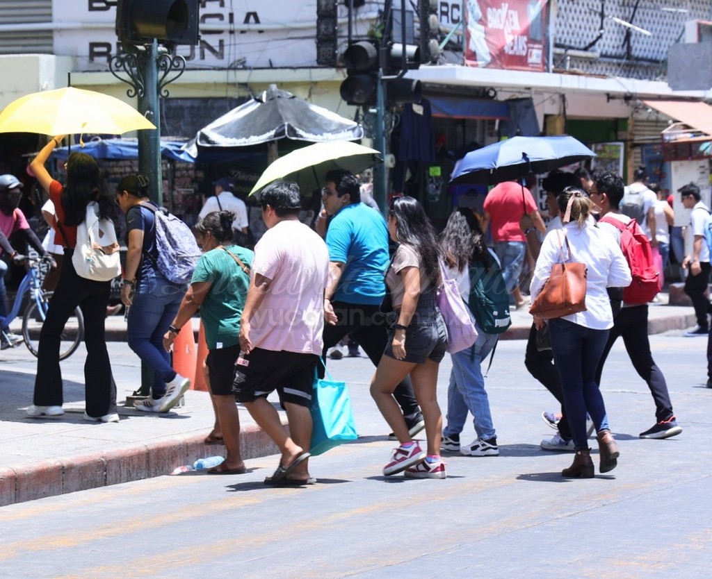 El intenso calor obliga a muchas personas a recurrir a sombrillas o sombreros para protegerse del Sol. La foto, de Sofía Vital, es de Mérida