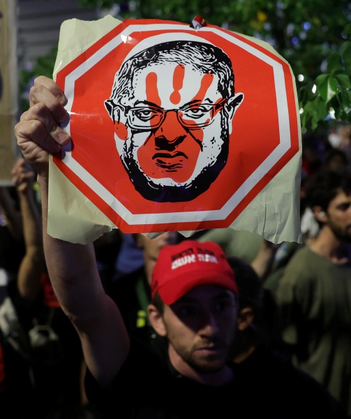 Un manifestante levanta un cartel con el rostro de Benjamín Netanyahu, durante una protesta frente al cuartel general militar de Kirya, en Tel Aviv