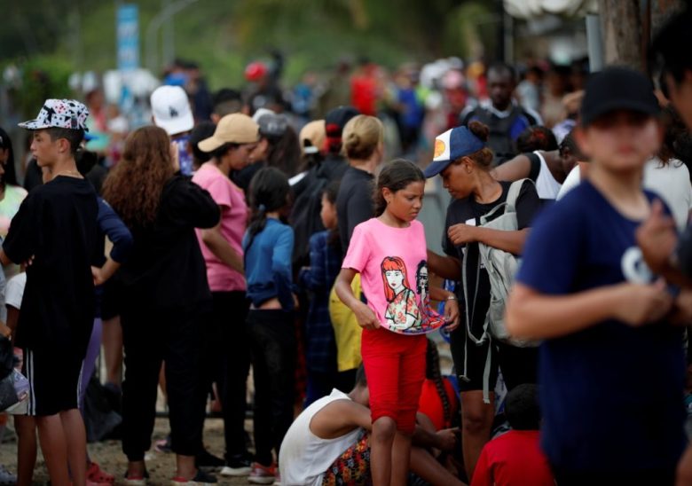 Migrantes que se dirigen hacia el norte llegan a Lajas Blancas, provincia de Darién, Panamá, después de cruzar caminando el Tapón del Darién desde Colombia. A la izquierda, migrantes van hacia una estación de recepción tras varios días en la selva del Darién rumbo a Estados Unidos