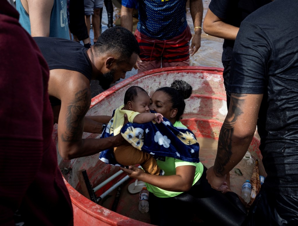 Una mujer es rescatada con su bebé en una zona inundada en la ciudad de Porto Alegre, Brasil, ayer