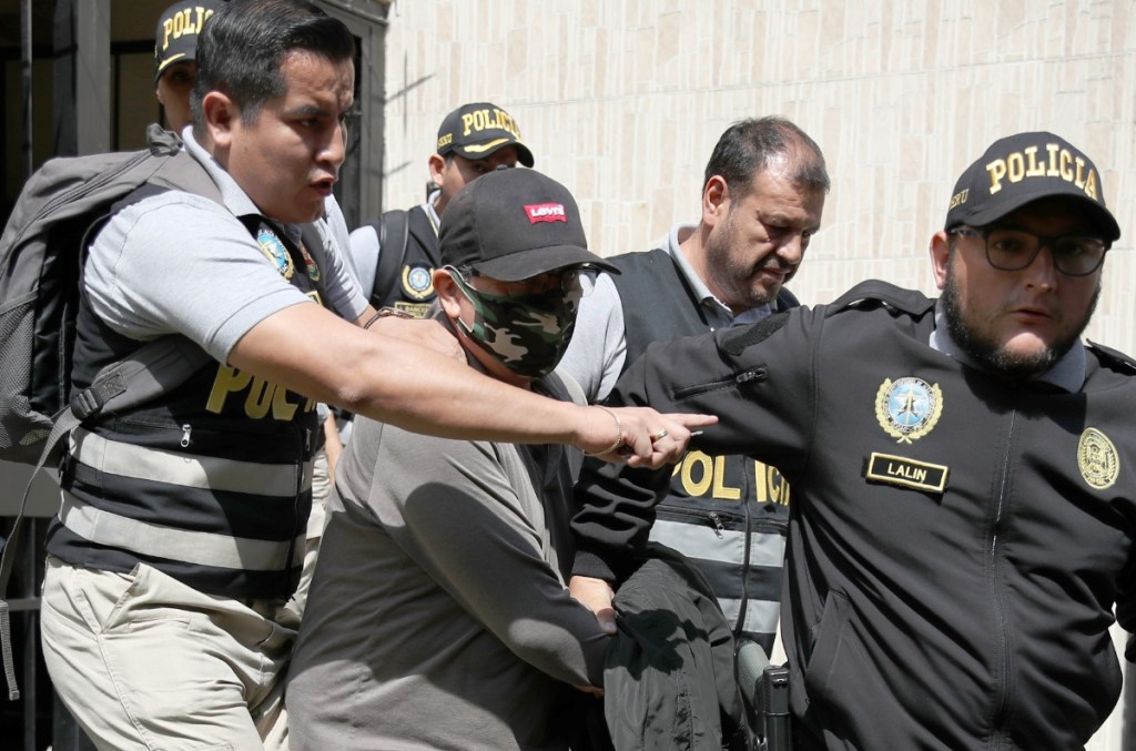 Policías trasladan a Nicanor Boluarte (centro) a la cárcel, durante su detención este viernes en Lima, Perú