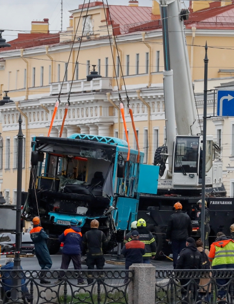 Socorristas levantan los restos de un autobús que se estrelló contra la valla del puente Potseluev en San Petersburgo