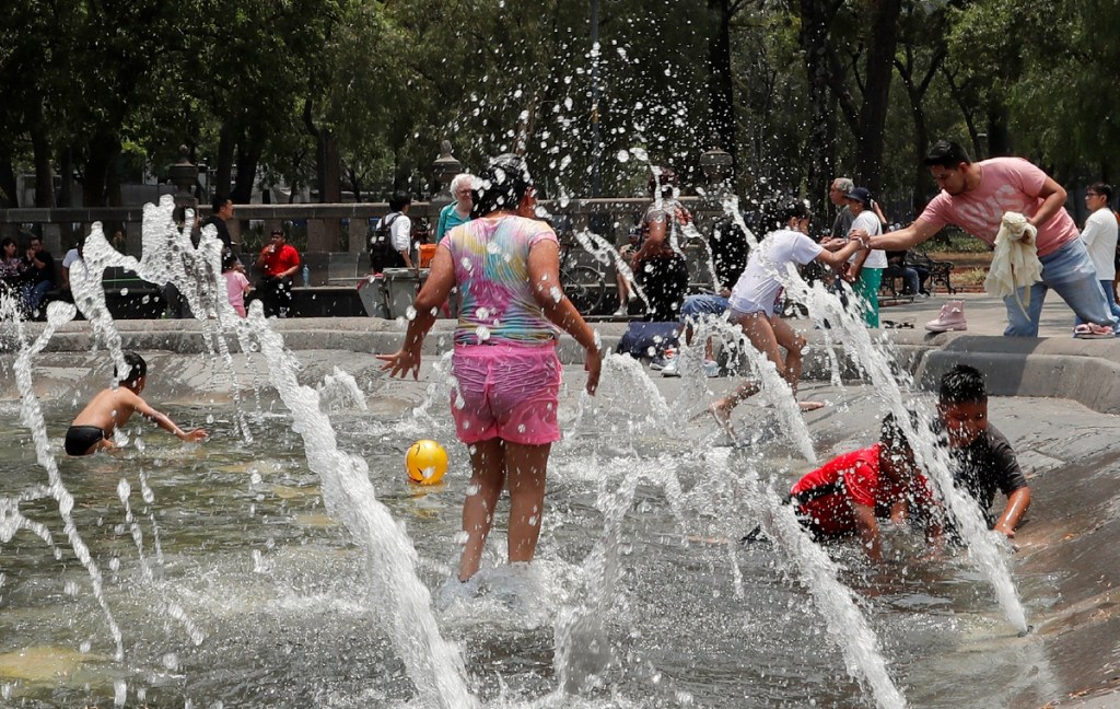 Niños juegan en una fuente de la Alameda Central, ayer en Ciudad de México. La onda de calor que azota desde hace 10 días a México cedería en algunos estados con lluvias en el sur, centro y norte del país