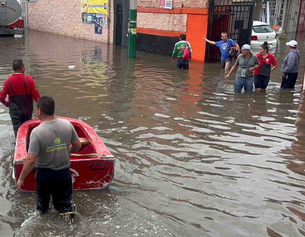 Los vecinosde Rancho San Blas que han decidido evacuar sus viviendas suben a las lanchas de Protección Civil y bomberos, cargando mochilas en cuyo interior resguardan documentos importantes, a fin de evitar algún daño debido a que el agua ingresó a sus domicilios