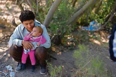 Como muchos, Sergio Franco, de Ecuador, sostiene a su hija mientras espera una oportunidad para solicitar asilo, cerca de la población de Dulzura, en California