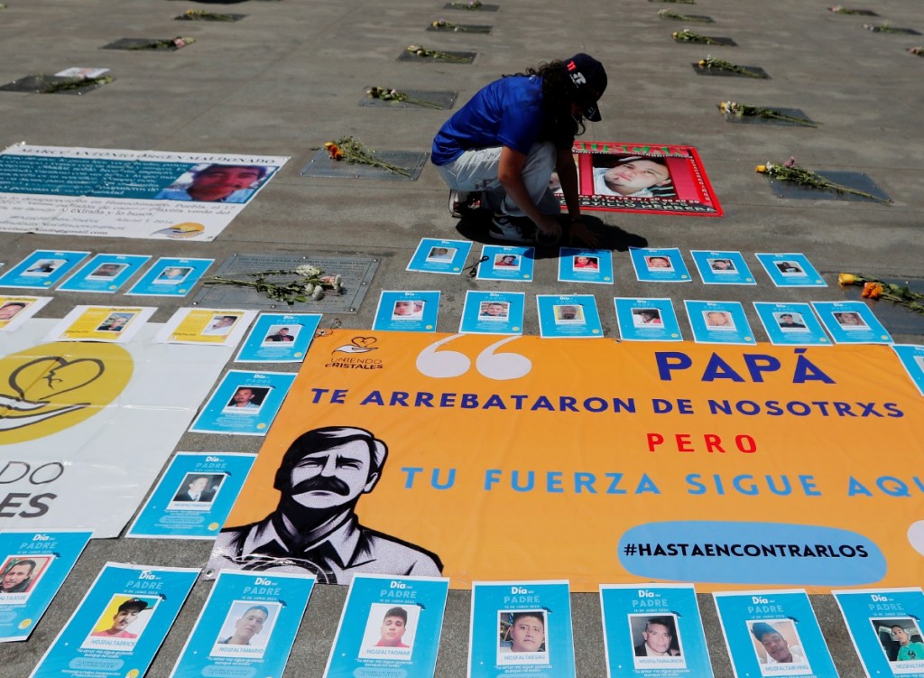 Una persona coloca fotografías en memoria de los padres desaparecidos, ayer en la Estela de Luz de Ciudad de México. La Oficina en México del Alto Comisionado de las Naciones Unidas para los Derechos Humanos (ONU-DH) honró ayer, en el marco del Día del Padre, a aquellos que buscan a sus hijas e hijos, y padres desaparecidos