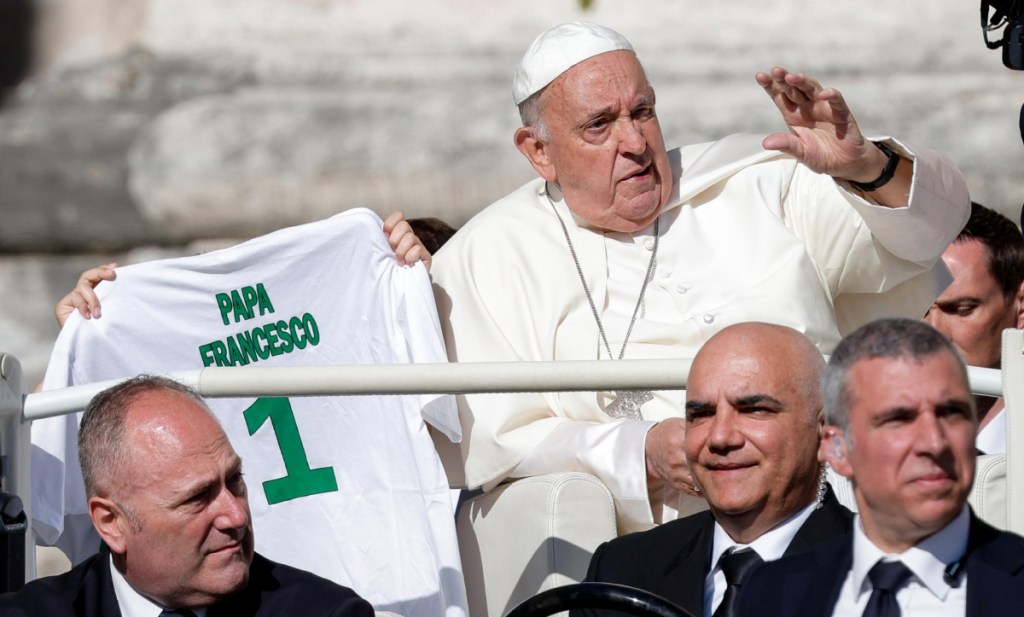 El papa Francisco saluda a su llegada para presidir la audiencia general semanal en la Plaza de San Pedro