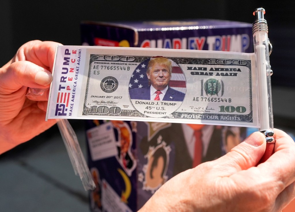 Una persona muestra un billete con la imagen de Donald Trump el sábado, antes de un mitin en Filadelfia