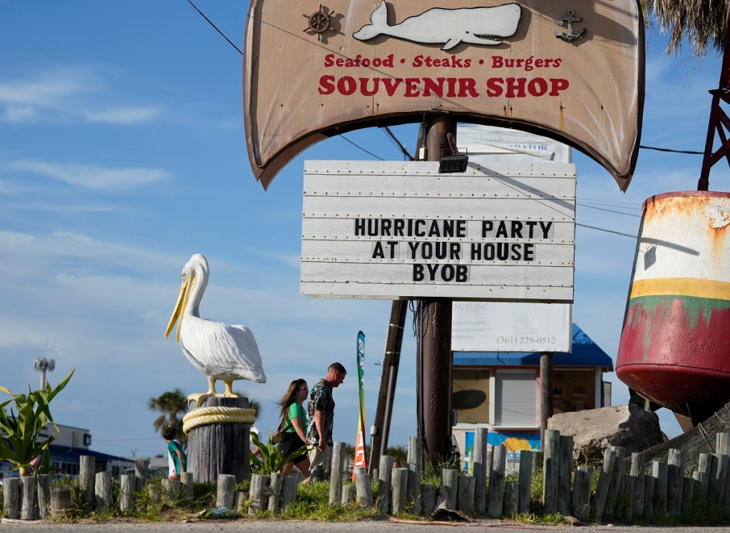 Visitantes pasan junto a un restaurante cerrado en Port Aransas, Texas, en previsión de la llegada de Beryl, que podría impactar como huracán (Foto de AP)