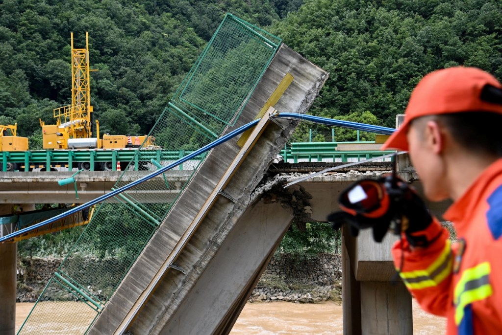 Rescatadores trabajan en el lugar del colapso de un puente en el condado de Zhashui, en la ciudad de Shangluo, provincia de Shaanxi