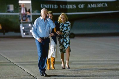 El presidente de Estados Unidos, Joe Biden, habla por teléfono camino a abordar el avión presidencial en la Base de la Fuerza Aérea McGuire