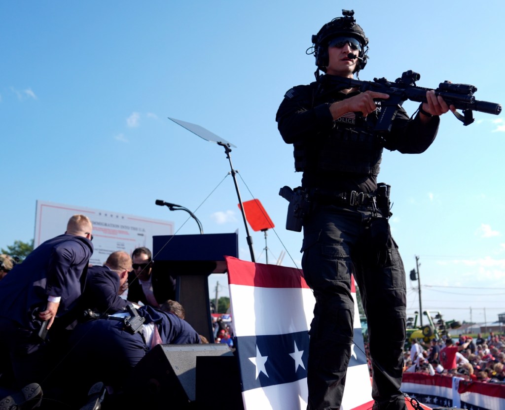 Agentes del Servicio Secreto protegen al candidato republicano a la presidencia Donald Trump, después de haber recibido un disparo que le “perforó” su oreja derecha