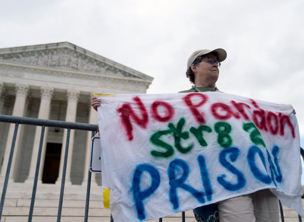 Un manifestante sostiene una pancarta contra Donald Trump frente a la Corte Suprema, en Washington