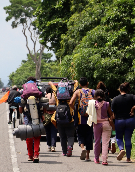 Arriba y a la izquierda, migrantes caminan en caravana en una carretera de Tapachula. La violencia está detrás del 80 % de los casos de migrantes con problemas de salud mental en la frontera sur, dice Médicos Sin Fronteras