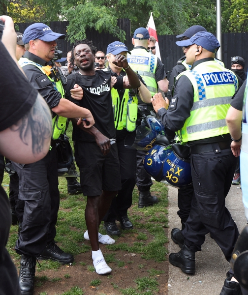 Un manifestante antirracista es apartado por las fuerzas del orden tras un enfrentamiento con miembros de la extrema derecha en Manchester. A la derecha, el primer ministro británico, Keir Starmer, ayer durante una conferencia de prensa.