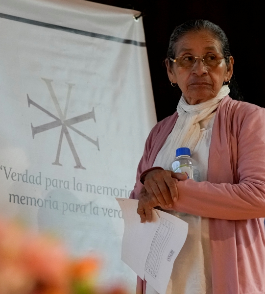 Tita Radilla, cuyo padre Rosendo Radilla desapareció, en la presentación de un informe sobre la “guerra sucia” entre 1965 y 1990 realizado por la Comisión de la Verdad, ayer en Ciudad de México. A la derecha, una joven coloca carteles de personas desaparecidas en el evento