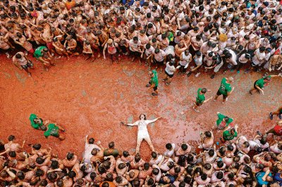 Sobre estas líneas y abajo, la batalla campal en que se convirtió ayer la “Tomatina”. A la izquierda, una joven pareja se besa mientras toma un descanso sobre el puré de tomate