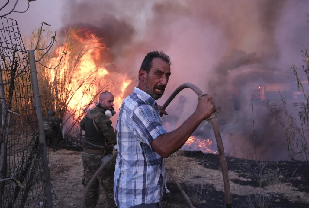 Sobre estas líneas, voluntarios combaten las llamas en el norte de Atenas. A la derecha, una mujer lleva a una clínica veterinaria a un gato que resultó con quemaduras ocasionadas por el incendio forestal, ayer, en la ciudad de Dionysos, en el norte de Ática, Grecia