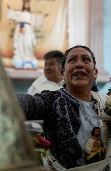 Arriba, devotos hacen fila para ver la reliquia de San Judas Tadeo mientras atraviesa los canales de Xochimilco, en Ciudad de México, ayer. A la izquierda, fieles católicos en una trajinera acompañando el recorrido con la reliquia del venerado santo