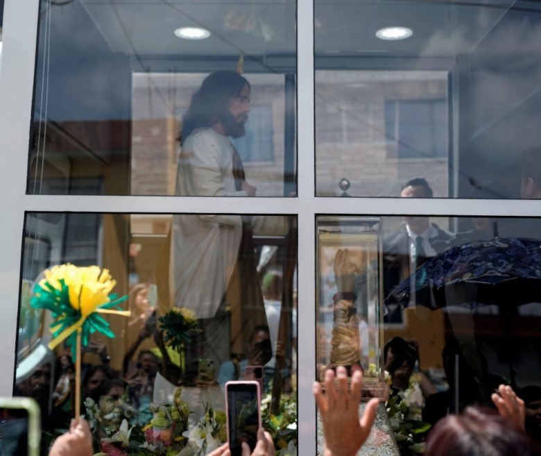 Los fieles saludan a una camioneta que transporta la reliquia de San Judas Tadeo a su llegada a la iglesia de San Cristóbal Mártir como parte de una gira nacional en San Cristóbal Texcalucan, México, el miércoles 7 de agosto de 2024.. (AP Foto/Eduardo Verdugo)