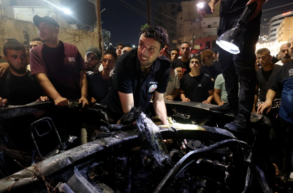 Personal de emergencia palestino intenta rescatar a sobrevivientes de un vehículo que fue golpeado tras un ataque aéreo israelí en la ciudad de Jenin, en Cisjordania, en el que fallecieron por lo menos dos personas