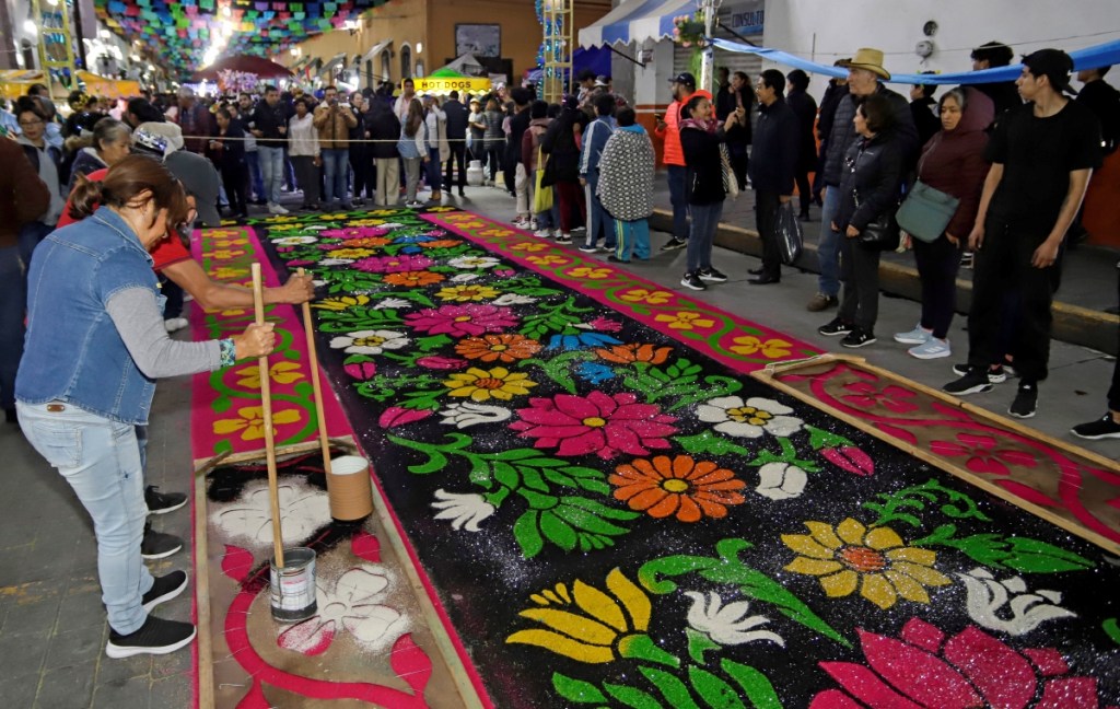 Tapetes monumentales de aserrín de hasta 100 metros de largo hechos por artesanos se desplegaron en una ruta de 7 kilómetros que simboliza el paso de la Virgen de la Caridad, en Huamantla, Tlaxcala