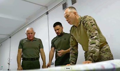 El presidente de Ucrania, Volodimir Zelenski, revisa planos en compañía de dos oficiales, durante la visita que realizó ayer la región nororiental de Sumy en su primera visita a la zona fronteriza desde la incursión