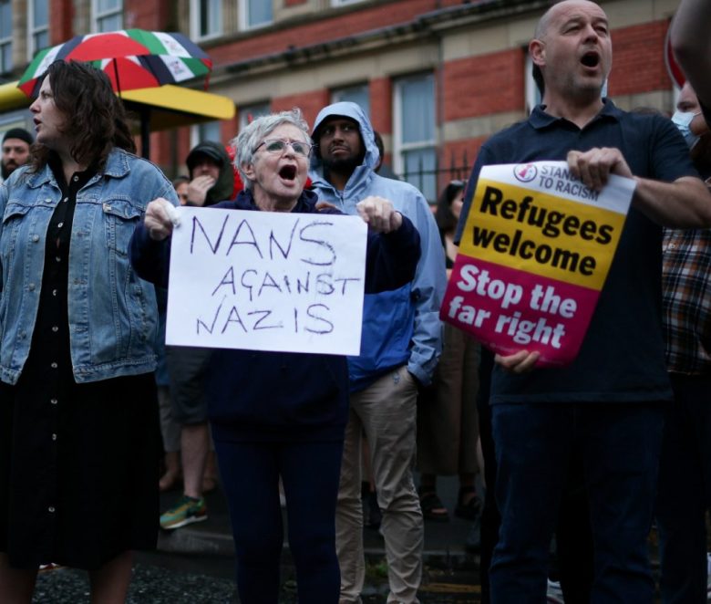 Un miembro de la mezquita Abdullah Quilliam en Liverpool estrecha la mano a un manifestante durante la protesta que tuvo lugar ayer frente a ese edificio religioso en contra de la violencia racista en Gran Bretaña