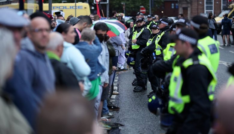 Agentes de policía forman una línea separando a manifestantes y contra-manifestantes durante una protesta ayer frente a la mezquita Abdullah Quilliam en Liverpool. Las personas se reunieron en la mezquita en respuesta a la amenaza de violencia de extrema derecha tras el fatídico ataque en Southport