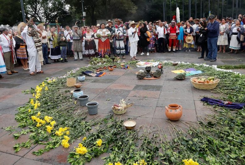 Un integrante del Consejo Nacional de Pueblos Indígenas ayer en Ciudad de México (izquierda). En la foto de abajo, una ceremonia por la reforma constitucional que promueve el gobierno de AMLO