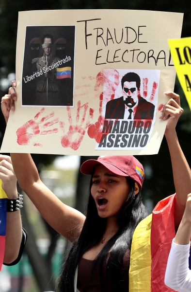 Venezolanos participan en una manifestación contra los resultados del CNE