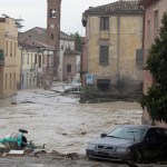 Estragos que causaron las lluvias en Traversara, Italia. Abajo, madre e hija llenan bolsas de arena para reforzar los diques contra inundaciones en la ciudad de Nowa Sol, Polonia